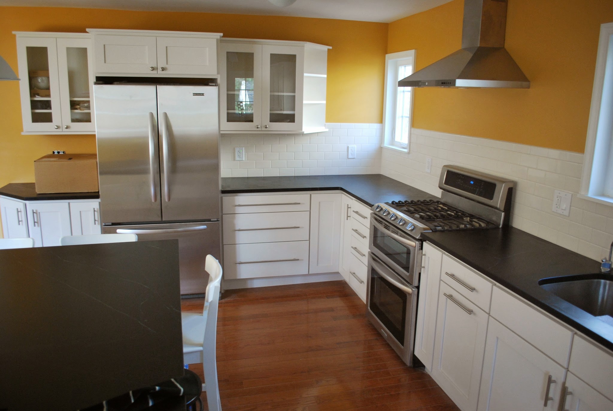 Completed kitchen with white cabinetry and dark counters